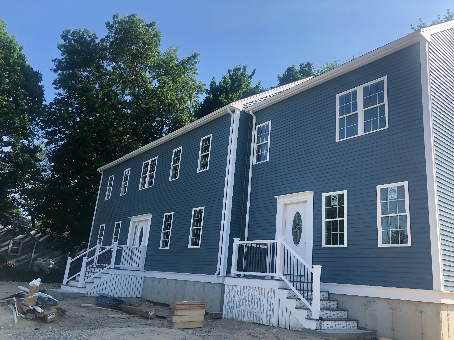 Two-story home with new blue lap siding, white trim, and new windows
