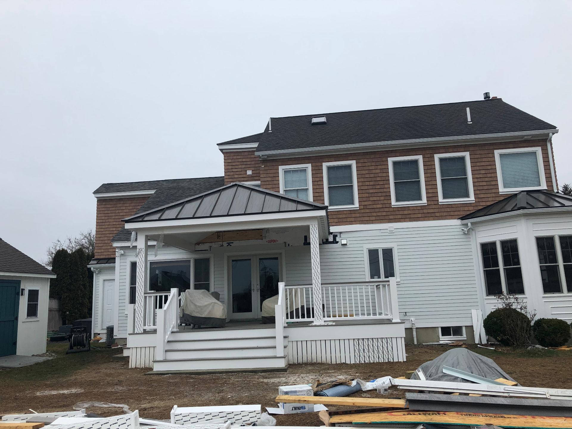 Home with cedar shingle siding, white lap siding, new windows, and a covered back porch