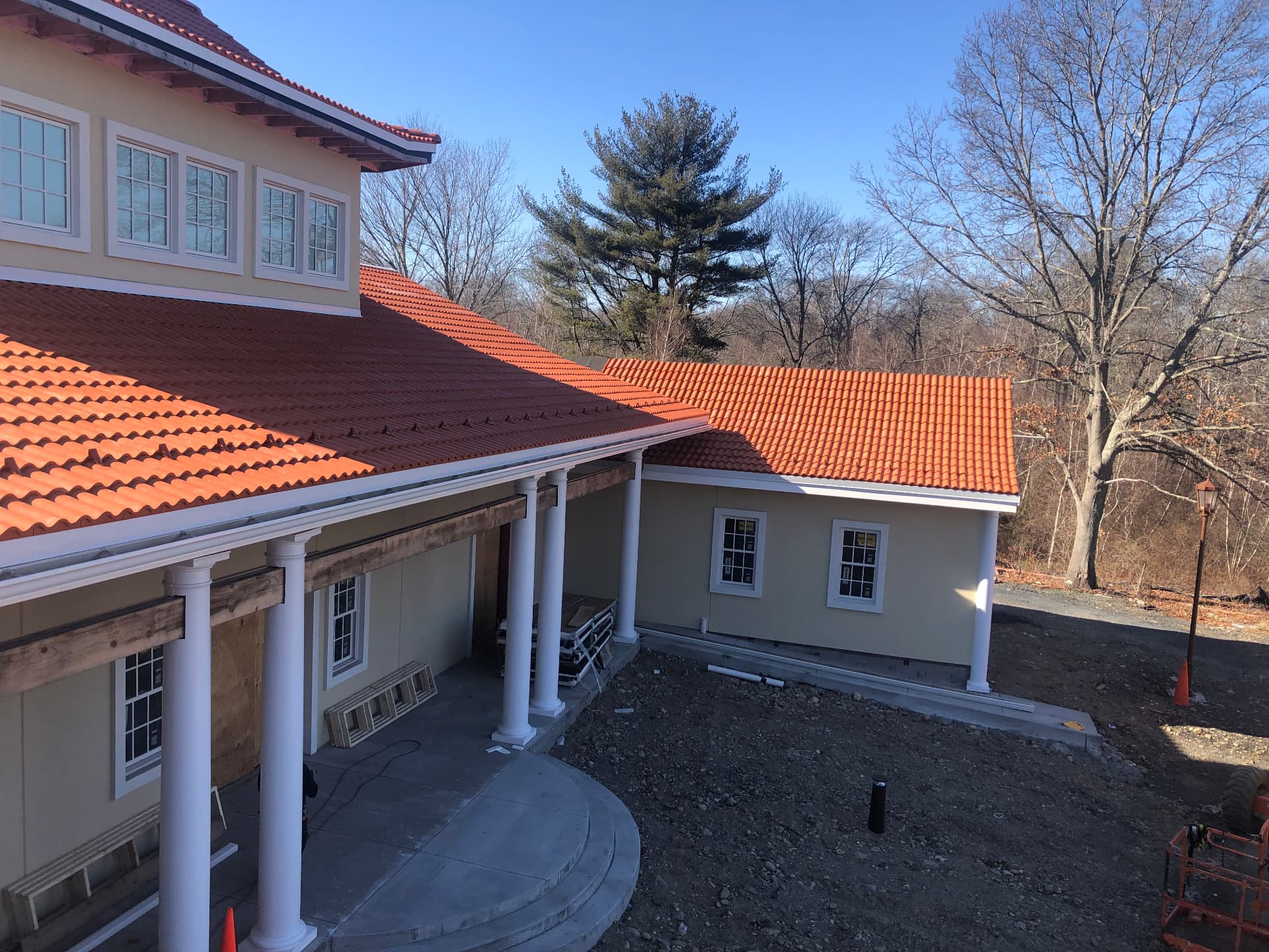 New orange clay tile roof on a home with white columns