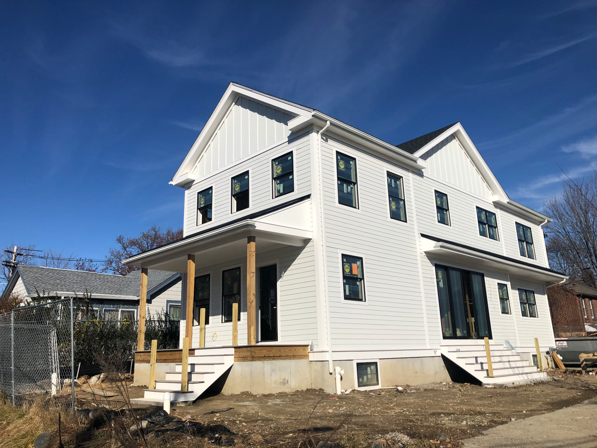 New two-story home with white lap and board-and-batten siding and black windows
